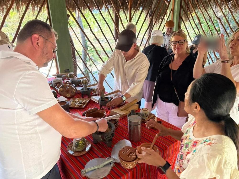 A guide at the stone-kitchen table showing guests how the tools work