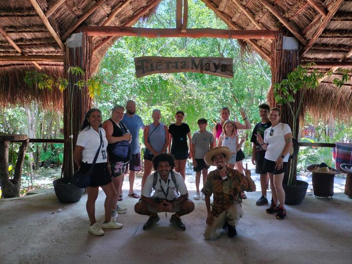 A group of about 12 with two guides kneeling at the entrance arch