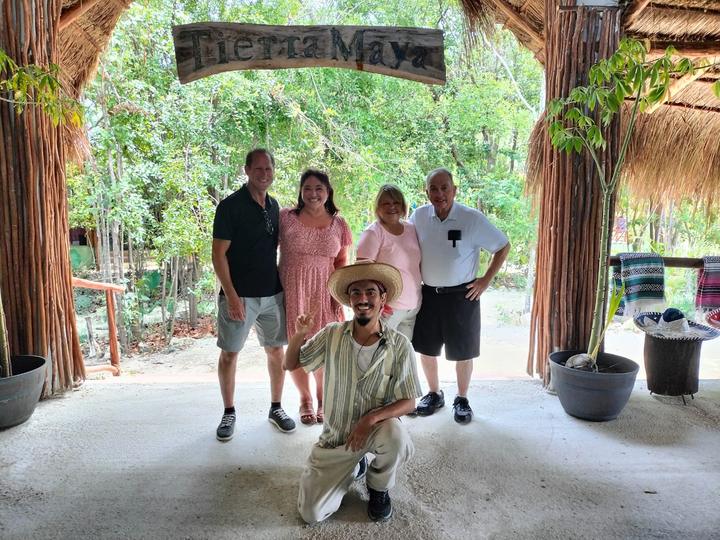 Four guests at the entrance arch, guide kneeling in a sombrero