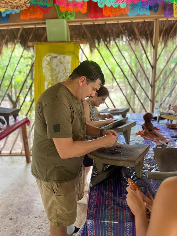 A guest grinding cacao at the metate table