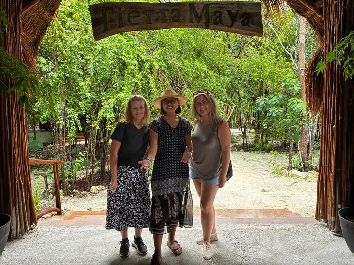 Three guests under the Tierra Maya sign